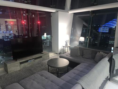 a living room with a couch and a tv at Amazing Skyline Views 3BR Duplex With Free Parking in Manchester