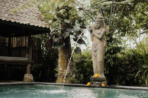 a statue of a woman standing next to a swimming pool at Moringa Ubud Villa in Ubud