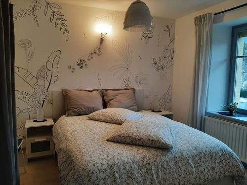- une chambre avec un lit orné de fleurs sur le mur dans l'établissement Chez Vovone 3 étoiles clévacances, à Saulxures-sur-Moselotte