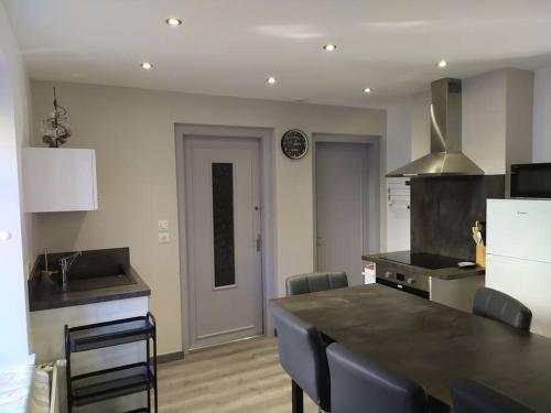 une cuisine avec un comptoir noir dans une pièce dans l'établissement Chez Vovone 3 étoiles clévacances, à Saulxures-sur-Moselotte