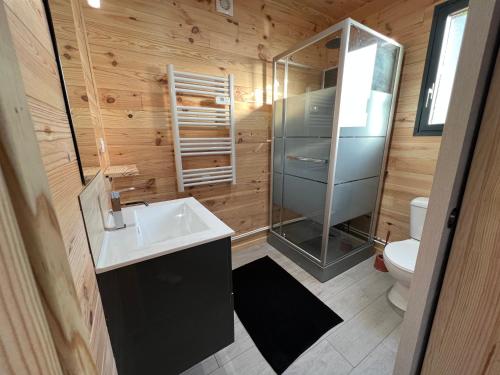 a bathroom with a sink and a shower and a toilet at Chalet contemporain ( chalet 2) in Montauban