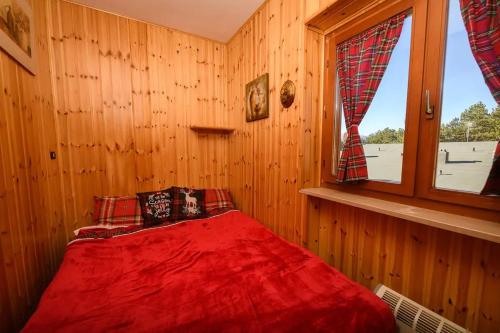 a bedroom with a red bed with a window at La Pineta di Giove - Casa Lory in Campo di Giove