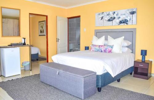 a bedroom with a large bed with a ottoman in it at Uitval Lodge & Conference Centre 