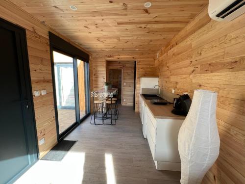 a kitchen in a log cabin with wooden walls at Chalet contemporain ( chalet 2) in Montauban