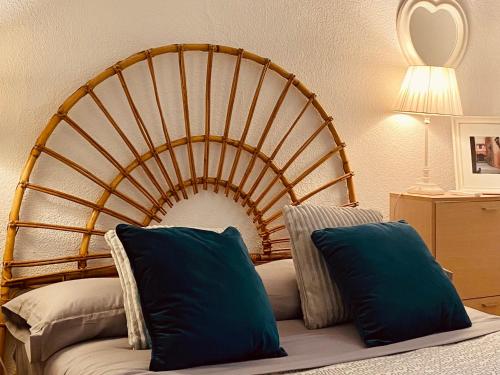 a bed with two blue pillows in a room at Bright Apartment steps from Plaza de Toros and Wizink Center in Madrid