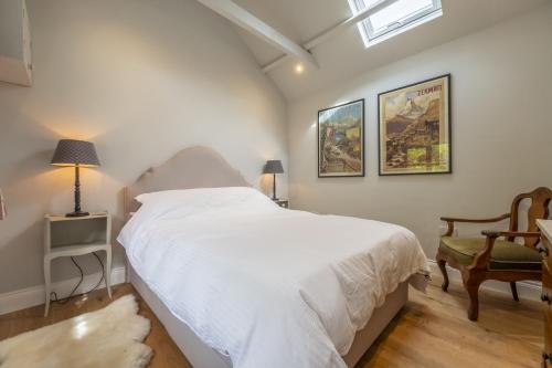 sypialnia z białym łóżkiem i krzesłem w obiekcie Weavers Mark Cottage w mieście Diss