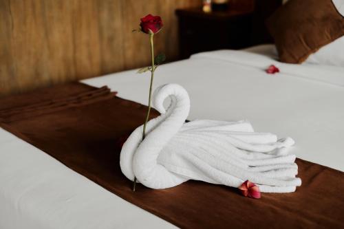 a towel swan on a wooden tray on a bed at Moringa Ubud Villa in Ubud