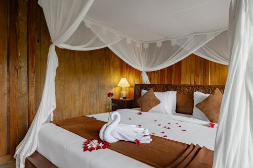 a bedroom with a bed with a swan on it at Moringa Ubud Villa in Ubud