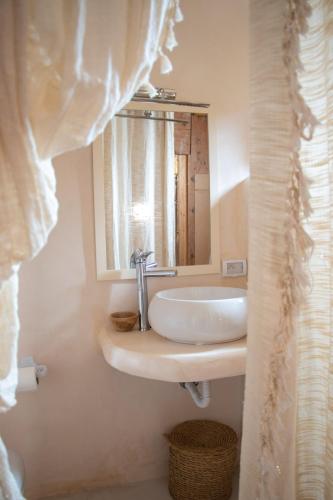 a bathroom with a sink and a mirror at Dar Shams - Les Houchs De Djerba in Erriadh