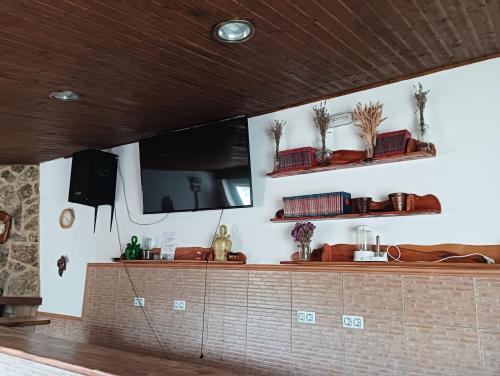 a kitchen with a counter and a tv on a wall at LA SOLANA in Valdemoro-Sierra