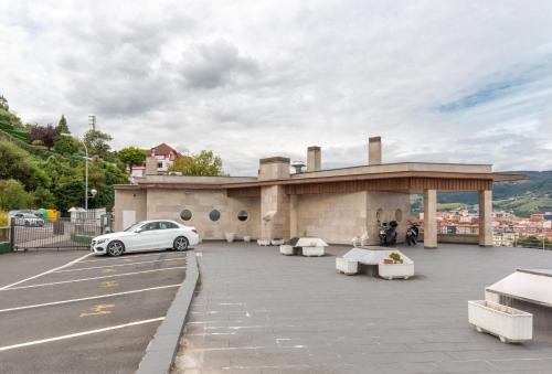 een gebouw met een auto geparkeerd op een parkeerplaats bij NEXT TO MUNDAKA in Bermeo