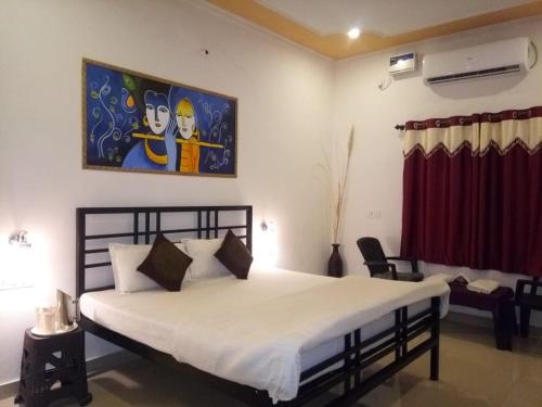 a bedroom with a large bed with a painting on the wall at Ranthambhore Tiger Valley in Sawāi Mādhopur