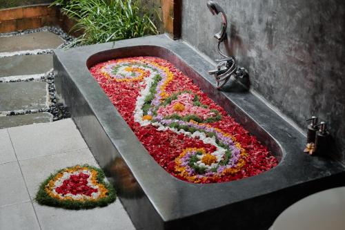 a sink filled with flowers in the shape of the number six at Moringa Ubud Villa in Ubud