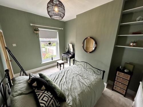 a bedroom with a bed and a mirror and a desk at Two Bed Charming Cottage in Crewe