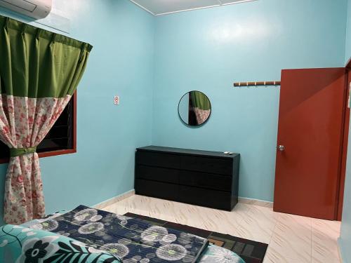 スガマッにあるSegamat Tunas Homestayのベッドルーム1室(ベッド1台、鏡、ドレッサー付)
