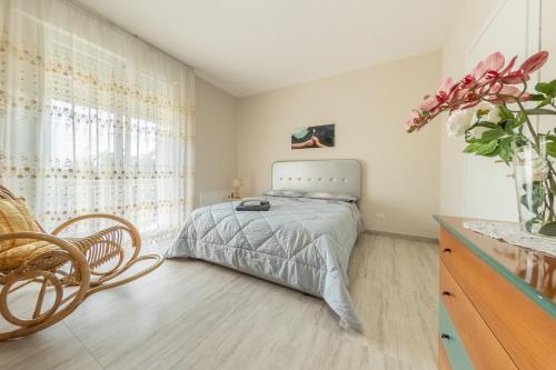 1 dormitorio con 1 cama y un jarrón de flores en B&b Villa Elena - Irpinia, en Mirabella Eclano