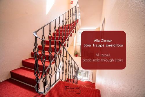 a staircase with red carpet and a sign on the wall at Boutique Hotel Kerlin in Berlin