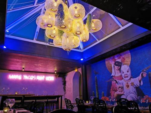 a large chandelier in a restaurant with a purple wall at Studio rez-de-villa - Parking facile - Proche gare in Toulon