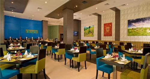 um restaurante com mesas e cadeiras num quarto em Fortune Park, Dahej- Member ITC's Hotel Group em Dahej