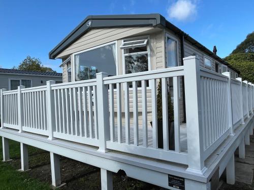 a small house with a white railing on a deck at Rockley Park Private Holiday Homes in Poole