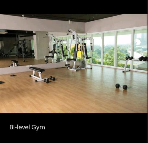 a gym with a large room with weights and machines at My Quiet Place at The Beacon - Makati City in Manila