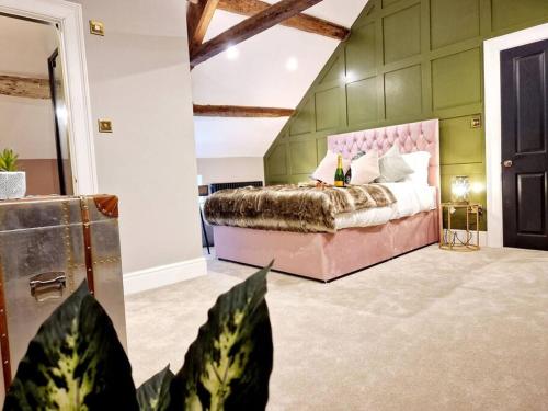 a bedroom with a bed with a pink head board at Hamilton-The Cruck Luxury Let in Scorton