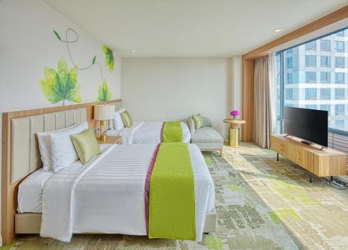 マニラにあるEastwood Richmonde Hotel - Newly Renovatedのベッド2台、薄型テレビが備わるホテルルームです。