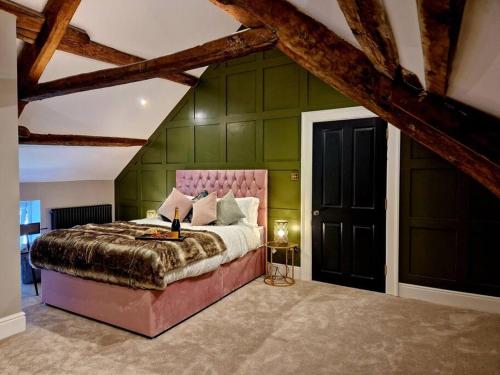 a bedroom with a large bed with green walls at Hamilton-The Cruck Luxury Let in Scorton