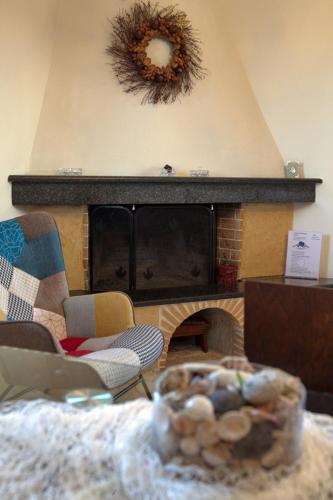 a living room with a fireplace with a wreath on the wall at House with sea breeze-Anemelia in Nafplio
