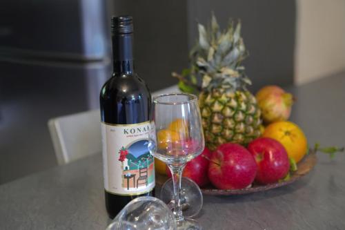a bottle of wine sitting next to a plate of fruit at House with sea breeze-Anemelia in Nafplio