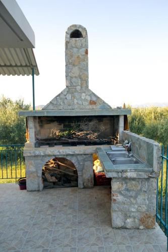 a stone fireplace with a sink in a yard at House with sea breeze-Anemelia in Nafplio