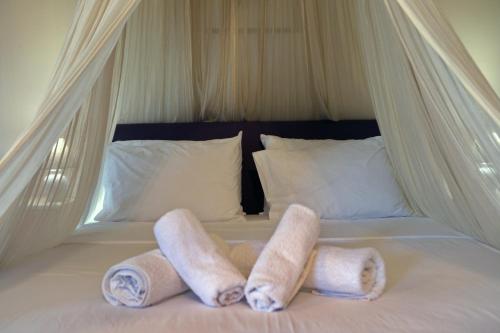 a bed with three rolls of towels on it at House with sea breeze-Anemelia in Nafplio