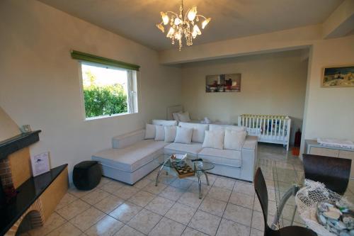 a living room with a white couch and a chandelier at House with sea breeze-Anemelia in Nafplio