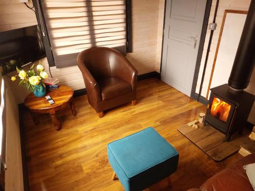 a living room with a chair and a wood stove at The Malvern Hills, Courtyard Cabins,Tom Cabin in Great Malvern