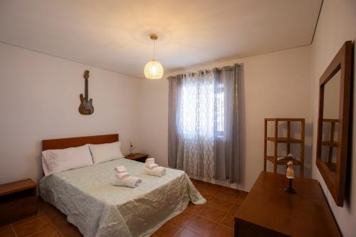 a bedroom with a bed with two towels on it at Emily's House in Arcos de Valdevez