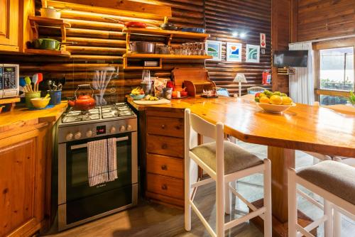 cocina con fogones y mesa con mesa en Under Milkwood Resort en Knysna