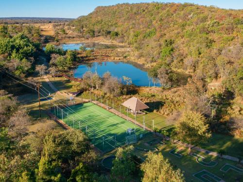 mit Blick auf einen Tennisplatz und einen See in der Unterkunft Waterberg Game Park in Mokopane