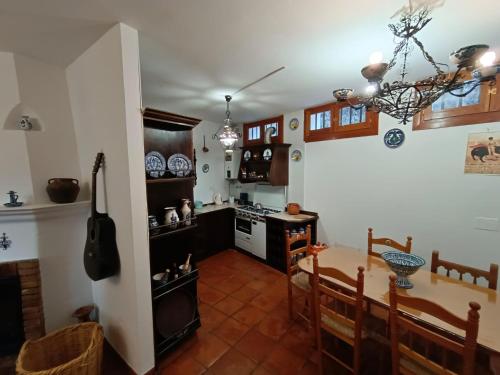 een keuken en eetkamer met een tafel en een fornuis bij Casa Rural La Argentina in Bubión