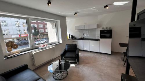 a living room with a couch and a kitchen at Luxus Appartement im Zentrum Düsseldorfs in Düsseldorf