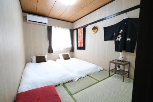 a small room with a white bed and a window at Housegreen in Tokyo