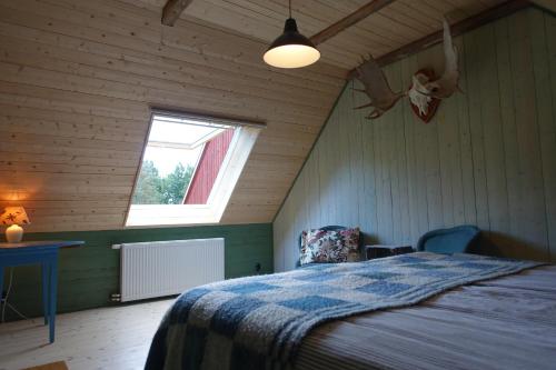 1 dormitorio con cama y ventana en Attic apartment on countryside en Mörarp