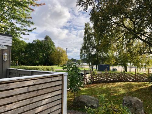 een houten hek voor een tuin met bomen bij Fint sjönära annex in Växjö