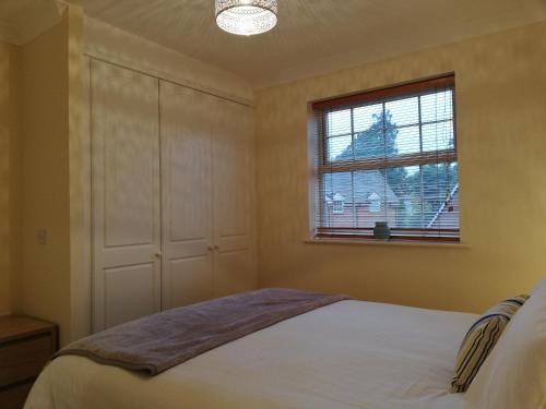 a bedroom with a bed and a window at Brand New 2 bed in one of Newbury oldest buildings in Newbury