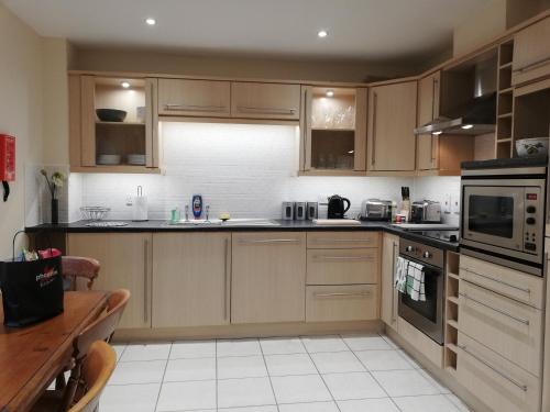 cocina con armarios de madera y horno con fogones en Brand New 2 bed in one of Newbury oldest buildings en Newbury