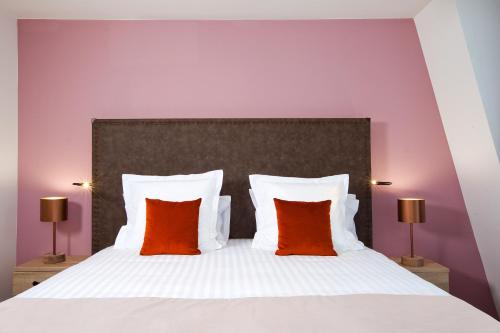 a bedroom with a large bed with two orange pillows at Residhome Puteaux La défense in Puteaux