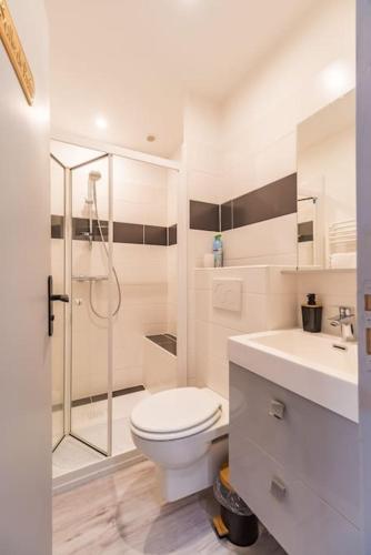 une salle de bain blanche avec toilettes et douche dans l'établissement Spacieux T2 proche plages côte de granite rose, à Trébeurden