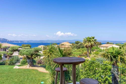 un tabouret posé au sommet d'une cour avec vue dans l'établissement Villa Palma Giens - Vue Mer Panoramique -Piscine Chauffée Mai à Septembre- 4 chambres -Garage, à Hyères