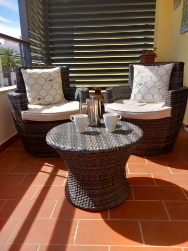 a patio with two chairs and a table at Portugal Home in Lagos