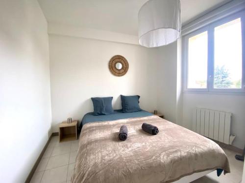 une chambre avec un grand lit avec des oreillers bleus dans l'établissement La Perle Noire - Vernon Giverny, à Vernon