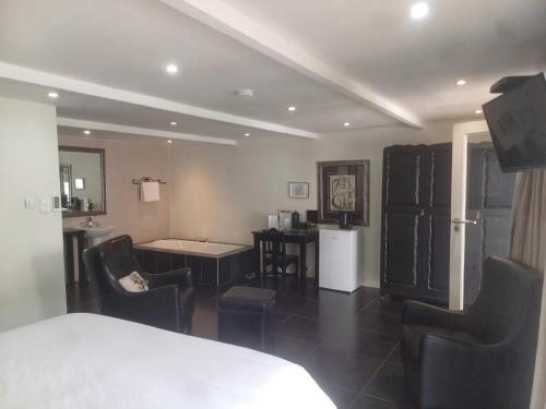 a room with chairs and a table and a kitchen at Thyme Wellness Spa and Guesthouse in Cape Town